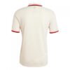 The image displays the rear of a cream-colored, short-sleeve Bayern Munich Third Jersey 24/25, featuring red sleeve and collar accents and a small embroidered logo near the back collar.