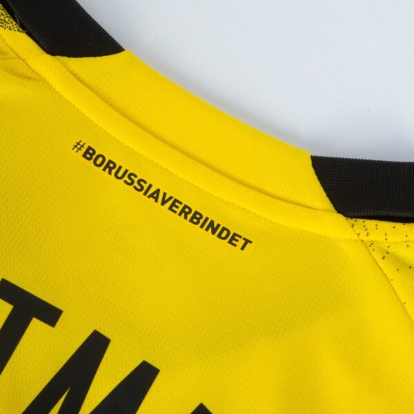 The Borussia Dortmund Third Jersey 23/24 is a vibrant yellow with a sleek black collar, featuring #BORUSSIAVERBINDET on the upper back and the partial letters TMA lower down for a mysterious detail.