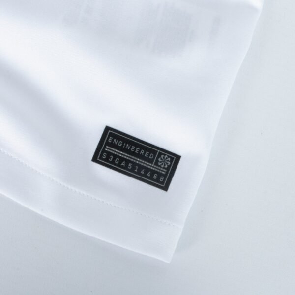 A close-up of the Eintracht Frankfurt Third Jersey 23/24 showcases smooth, white fabric with a neatly folded edge. A black label displays Engineered in white alongside a small star-like or geometric logo on the right.