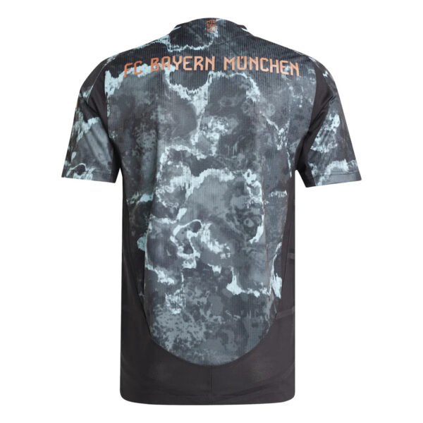 The back of the FC Bayern Munich Away Jersey 24/25 displays a grey and black camouflage pattern, with the clubs name prominently printed in vibrant orange letters across the upper back.