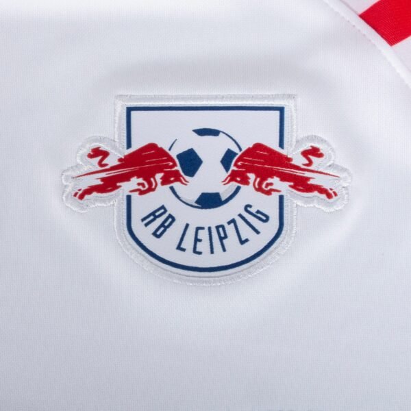 The image shows the RB Leipzig logo, with two red bulls around a soccer ball and RB Leipzig beneath. This emblem appears on a white fabric, part of their iconic apparel.