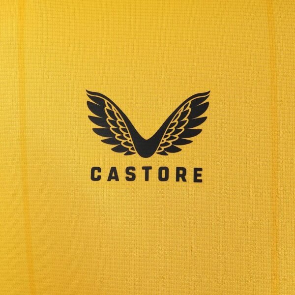A close-up of the Wolverhampton Home Jersey 23/24 reveals yellow fabric with a black castore logo, showcasing a stylized V resembling wings above the word CASTORE.