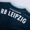 The RB Leipzig Third Jersey 24/25 features RB Leipzig in bold white across the upper back, with You Can Do Anything beneath and a light blue trim on the collar for striking contrast.