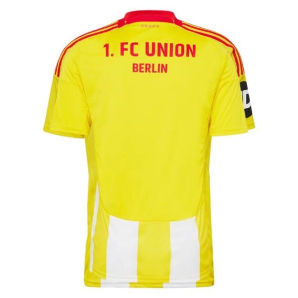 The Union Berlin Third Jersey 24/25 is a yellow soccer jersey with red accents and 1. FC UNION BERLIN on the back, featuring striking red shoulder stripes and a bold black JD sleeve patch.