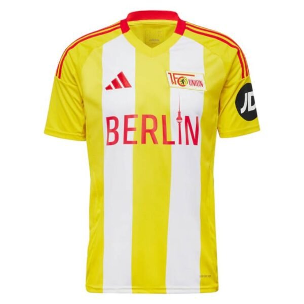 The Union Berlin Third Jersey 24/25 flaunts yellow and white stripes with bold red accents, features BERLIN in red lettering, the Union emblem on the chest, and a black circular JD logo on the sleeve.